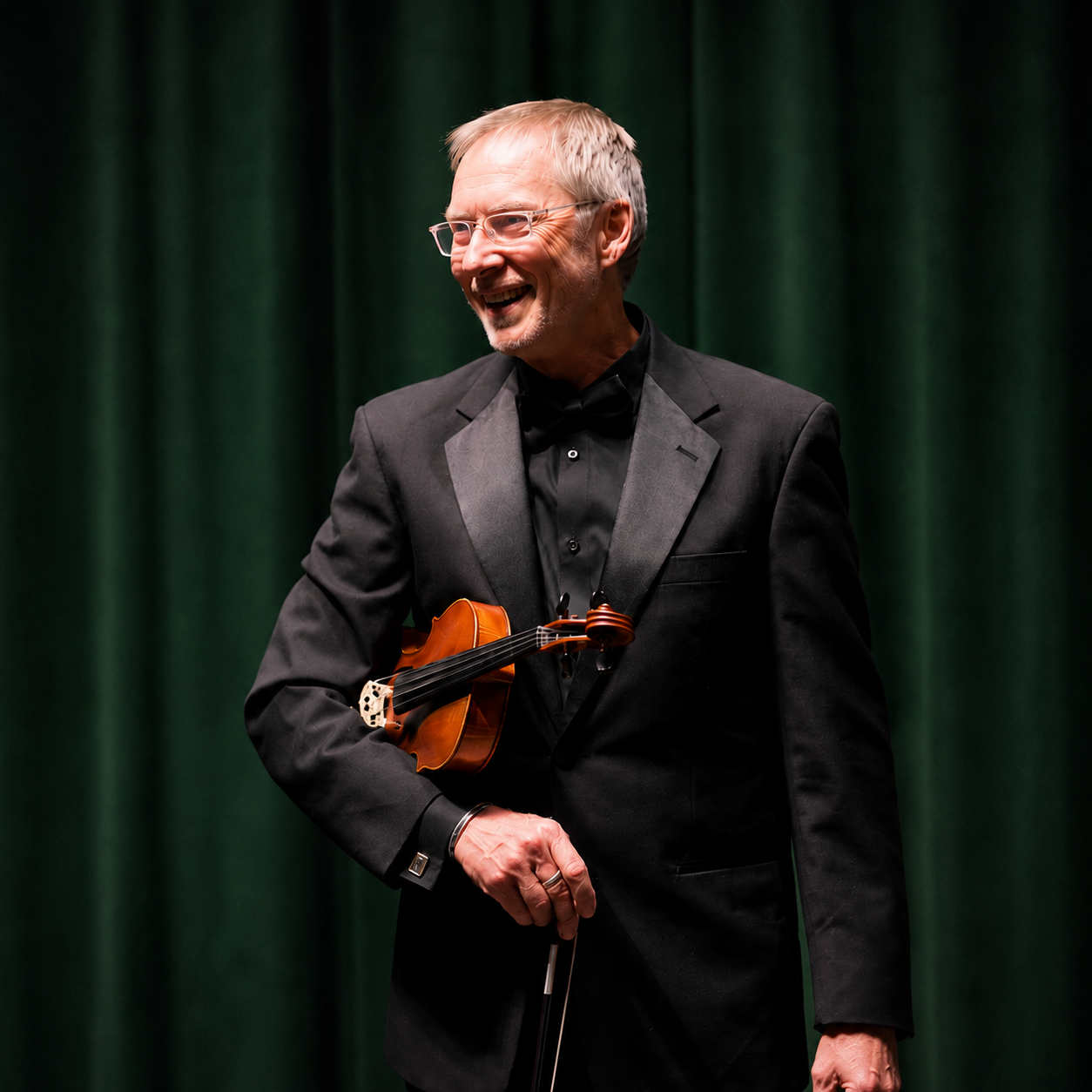 Mark Hill in formal concert attire holding a violin